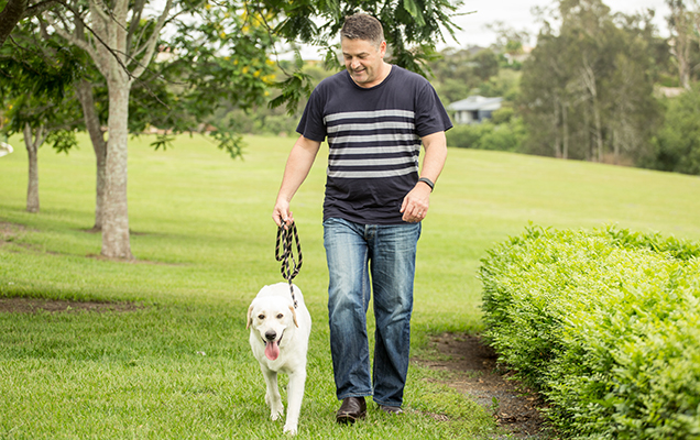 Nick walking his dog Jack in a park